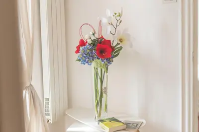 a vase filled with flowers sitting on a table at Pellegrino 75 Double Bedroom in Rome