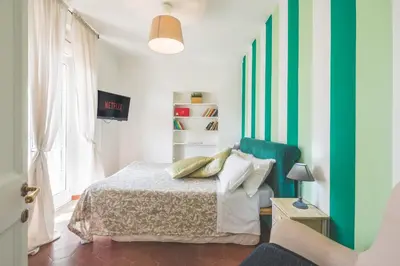 a bedroom with a bed and a green accent wall at Pellegrino 75 Double Bedroom in Rome