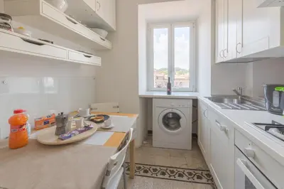 a white kitchen with a washing machine in it at Pellegrino 75 Double Bedroom in Rome