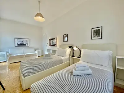 a bedroom with two beds and a living room at Elegant Vatican Metro & Golf Rome in Rome