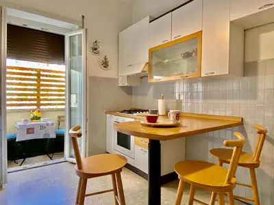 a kitchen with white cabinets and a table and chairs at Elegant Vatican Metro & Golf Rome in Rome
