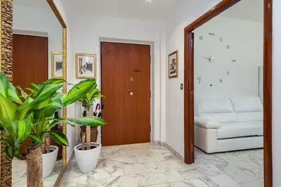 a hallway with a door and plants and a couch at Elegant Vatican Metro & Golf Rome in Rome