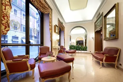 a lobby with chairs and tables and a large window at Hotel Della Torre Argentina in Rome