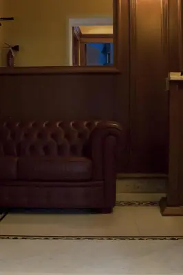 a brown couch in a room with a mirror at Clara Domus in Rome