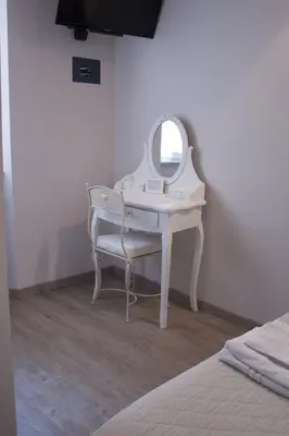 a dressing table with a mirror next to a bed at Clara Domus in Rome