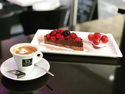 a plate with a piece of cake and a cup of coffee at THE ONE Boutique Hotel & SPA Roma in Rome