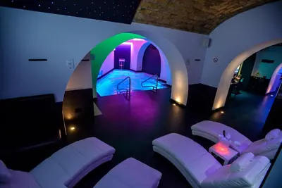 a room with a pool and a room with white chairs at THE ONE Boutique Hotel & SPA Roma in Rome
