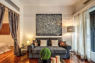 a living room with a couch and a painting at Lovely apartment close Vatican in Rome