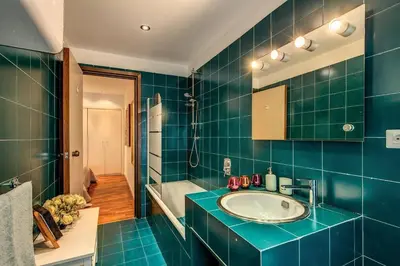 a blue bathroom with a sink and a tub at Lovely apartment close Vatican in Rome
