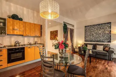 a kitchen and living room with a table and a couch at Lovely apartment close Vatican in Rome