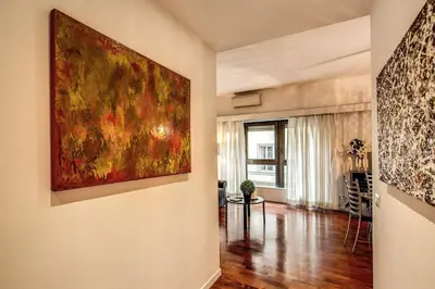 a living room with a large painting on the wall at Lovely apartment close Vatican in Rome