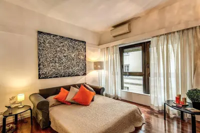 a bedroom with a bed with orange pillows and a window at Lovely apartment close Vatican in Rome