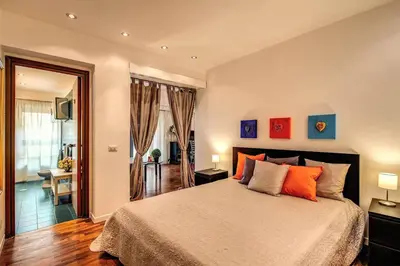 a bedroom with a large bed with orange pillows at Lovely apartment close Vatican in Rome