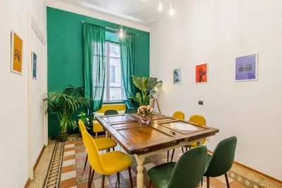 a dining room with a wooden table and yellow chairs at Home Of Arts in the Center in Rome