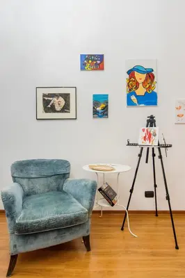 a living room with a blue chair and a table at Home Of Arts in the Center in Rome