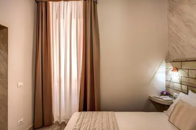 a bedroom with a bed and a window with curtains at Colosseo Accomodation Room Guest House in Rome
