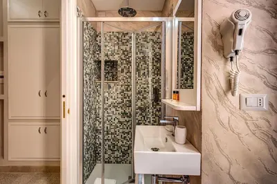 a bathroom with a shower with a sink and a shower at Colosseo Accomodation Room Guest House in Rome