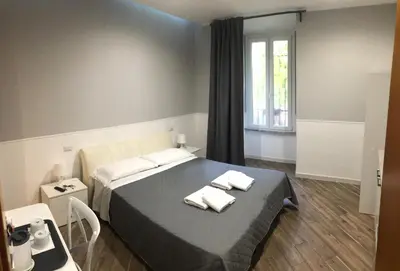 a bedroom with a bed with two towels on it at Rent Rooms Colosseum in Rome