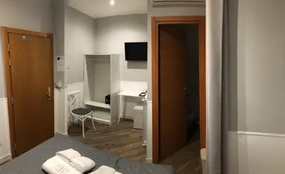 a hotel room with a bed and a bathroom at Rent Rooms Colosseum in Rome