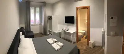 a hotel room with a bed and a television at Rent Rooms Colosseum in Rome