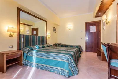 a hotel room with a bed and a mirror at Raeli Hotel Lux in Rome