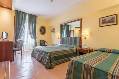 a hotel room with two beds and a mirror at Raeli Hotel Lux in Rome