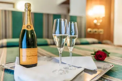 a bottle of wine and two wine glasses on a table at Raeli Hotel Luce in Rome