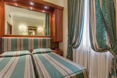 a bedroom with a bed in front of a mirror at Raeli Hotel Luce in Rome
