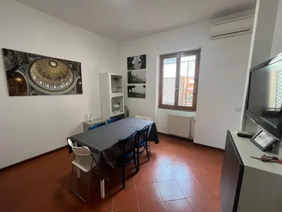 a dining room with a table and a television at Vista Cupola House in Rome