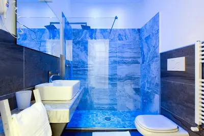 a blue bathroom with a sink and a toilet at Art Atelier Borgo in Rome
