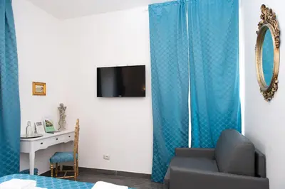 a living room with a blue curtain and a desk at Art Atelier Borgo in Rome