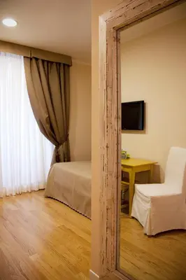 a mirror reflection of a bedroom with a bed and a desk at Residenza Dei Gracchi in Rome
