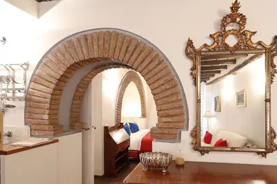 an archway in a room with a bed and a mirror at Loft In Rome Termini-Colosseum in Rome