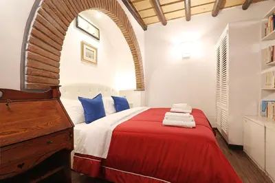 a bedroom with a red and white bed with a wooden dresser at Loft In Rome Termini-Colosseum in Rome