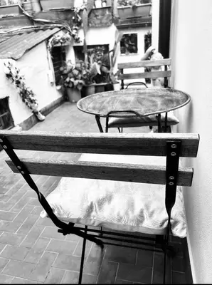 a black and white photo of a bench with a table at Spagna Rooms in Rome