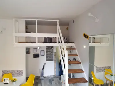 a room with a loft bed and yellow chairs at La Roma di Camilla in Trastevere in Rome