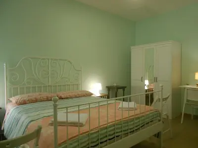 a bedroom with a bed and a dresser in it at L'Oleandro di Alfredo in Rome