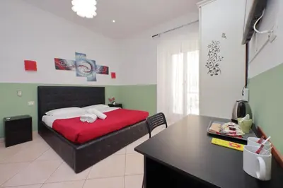 a bedroom with a bed with a red blanket and a desk at Dandi Domus in Rome