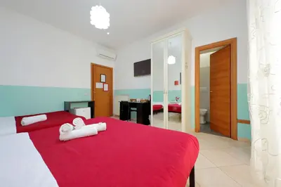 a bedroom with a red bed with towels on it at Dandi Domus in Rome