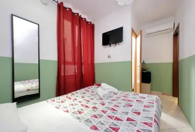a bedroom with a bed and a mirror and a television at Dandi Domus in Rome