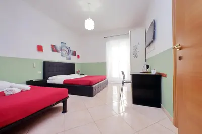 a bedroom with two beds and a television in it at Dandi Domus in Rome