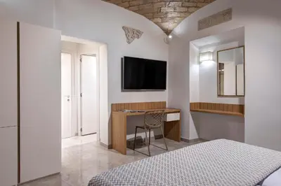 a bedroom with a bed and a desk with a television at Magica Luna Boutique Hotel - Roma in Rome