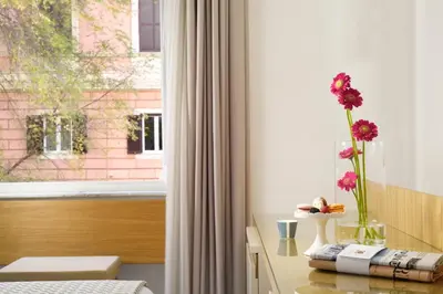 a room with a window with a vase with flowers on a table at Magica Luna Boutique Hotel - Roma in Rome