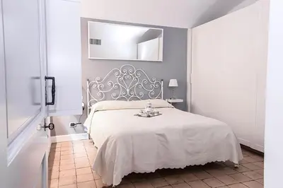 a bedroom with a white bed and a mirror at Sweet Rome Colosseo in Rome