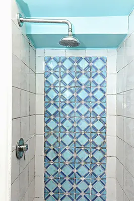 a shower with a blue and white tiled wall at Sweet Rome Colosseo in Rome