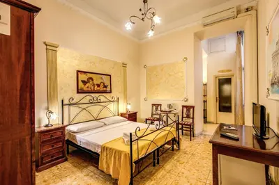 a bedroom with a bed and a desk and a television at GuestHouse o Affittacamere Magenta Baylon Suite in Rome