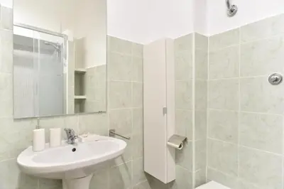 a white bathroom with a sink and a mirror at GuestHouse o Affittacamere Magenta Baylon Suite in Rome