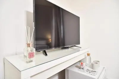 a large flat screen tv on a white wall in a living room at GuestHouse o Affittacamere Magenta Baylon Suite in Rome