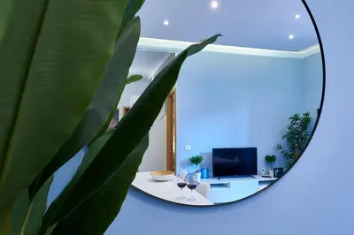 a mirror reflecting a living room with a table and a tv at Good Vibes Rome comfort and quality in Rome
