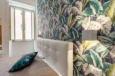 a bedroom with a bed with a floral wallpaper at Good Vibes Rome comfort and quality in Rome